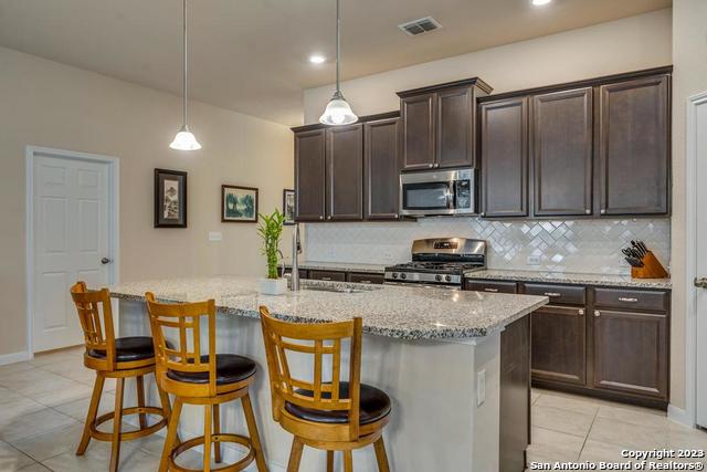 12515 Ponder Ranch San Antonio, TX 78245 - Photo 11 of 27 a kitchen with granite countertop wooden cabinets and a granite counter tops