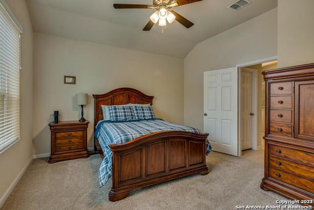 12515 Ponder Ranch San Antonio, TX 78245 - Photo 17 of 27 a bedroom with a bed and a chandelier