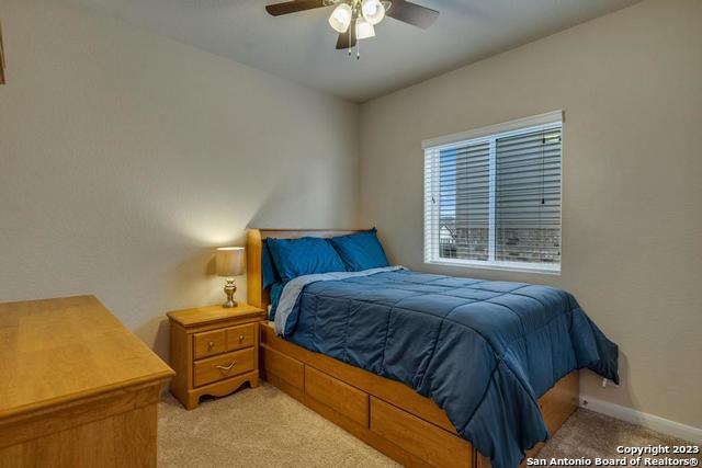 12515 Ponder Ranch San Antonio, TX 78245 - Photo 20 of 27 a bedroom with a bed and a chandelier
