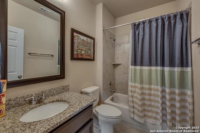 12515 Ponder Ranch San Antonio, TX 78245 - Photo 21 of 27 a bathroom with a granite countertop sink toilet and shower