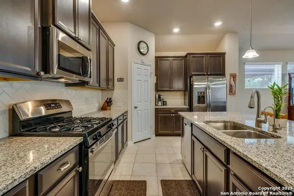 a kitchen with stainless steel appliances granite countertop a sink stove and refrigerator