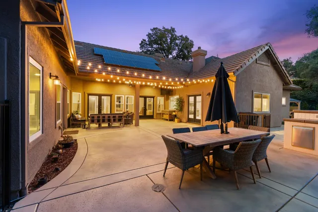 a view of a patio with a table and chairs under an umbrella