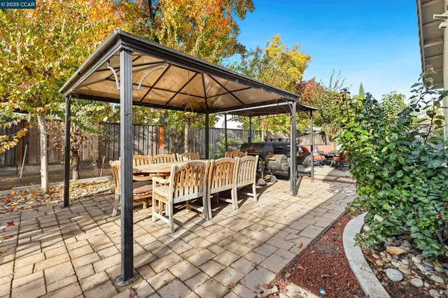 a view of patio with table and chairs under an umbrella