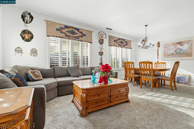 a living room with furniture and a chandelier
