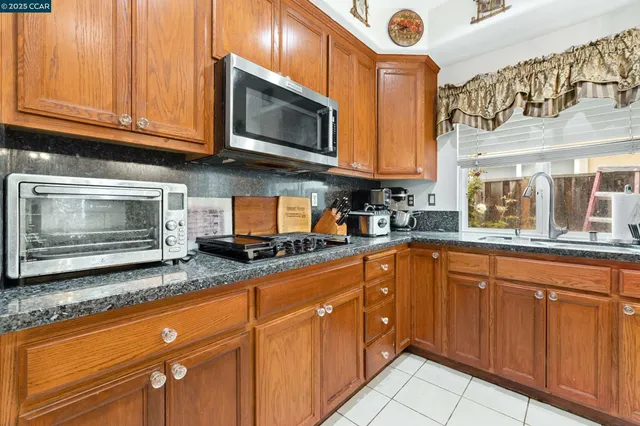 a kitchen with stainless steel appliances granite countertop a sink a stove microwave and cabinets