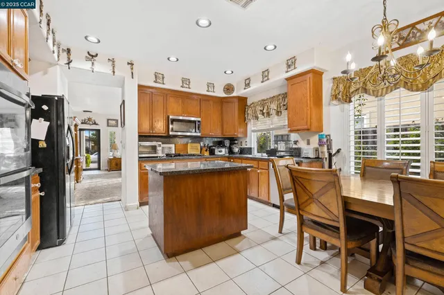 a kitchen with stainless steel appliances granite countertop a refrigerator a oven and a stove
