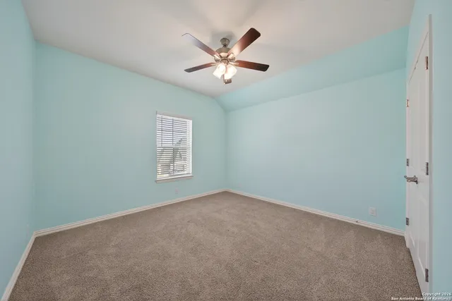a view of an empty room with a ceiling fan