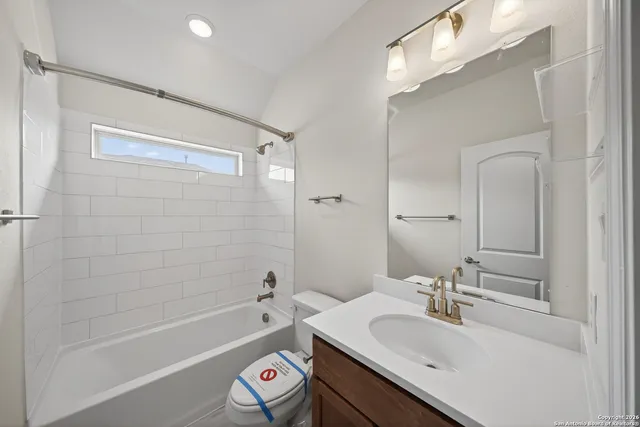 a bathroom with a granite countertop sink mirror toilet and bathtub