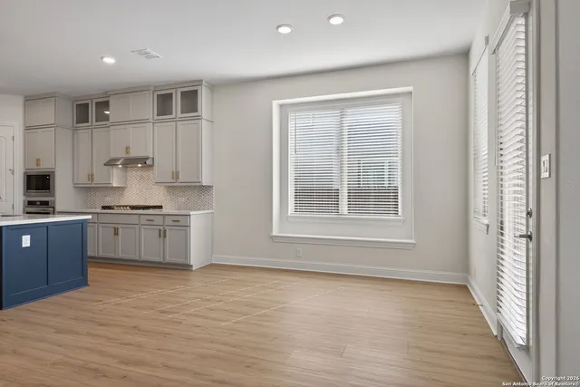 a kitchen with stainless steel appliances white cabinets and wooden floor