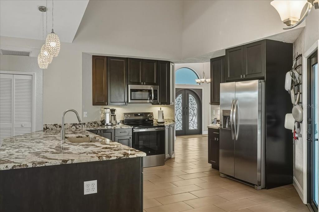 7314 Powder Puff Punta Gorda, FL 33955 - Photo 14 of 48 a kitchen with stainless steel appliances granite countertop a refrigerator a stove a sink and a microwave