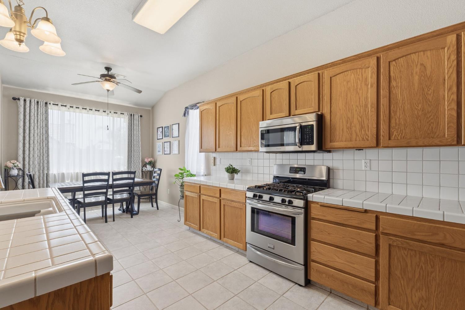 1757 Homestead Way Lemoore, CA 93245 - Photo 10 of 35 a kitchen with granite countertop a stove chairs and cabinets
