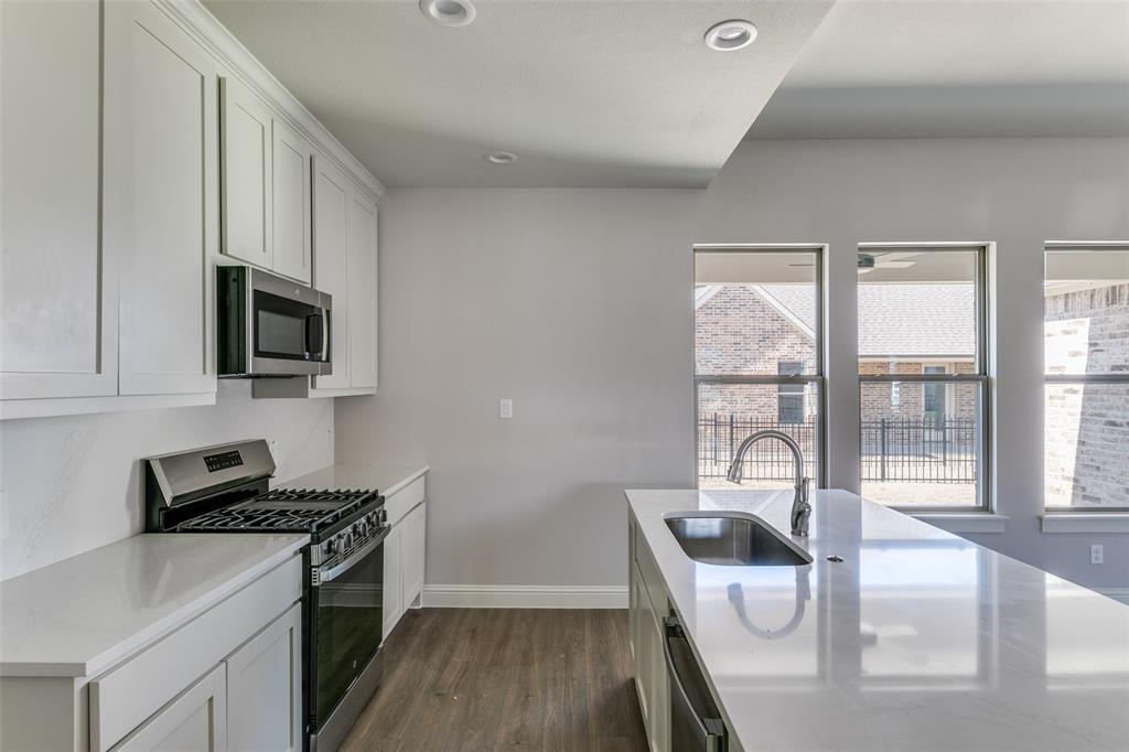 622 Community Lane Rockwall, TX 75087 - Photo 16 of 27 a kitchen with a stove a sink and a microwave