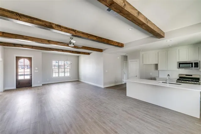 a view of a kitchen with furniture and wooden floor