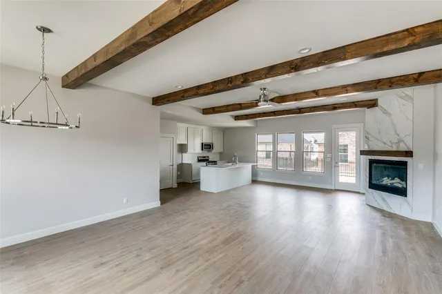a view of a room with wooden floor fireplace and windows
