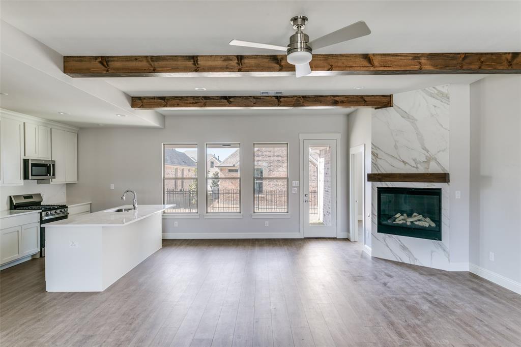 622 Community Lane Rockwall, TX 75087 - Photo 10 of 27 a living room with stainless steel appliances granite countertop a stove top oven a sink and a fireplace