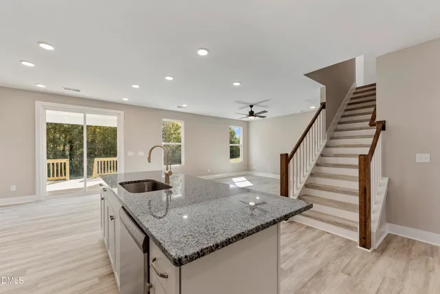 a kitchen with stainless steel appliances granite countertop a sink and a wooden floors