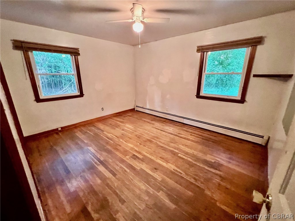 1642 Regent Road Topping, VA 23169 - Photo 8 of 10 Bedroom room with a baseboard radiator, wood-type flooring, and ceiling fan