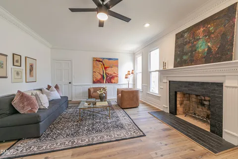 a kitchen with granite countertop a table chairs stove and white cabinets