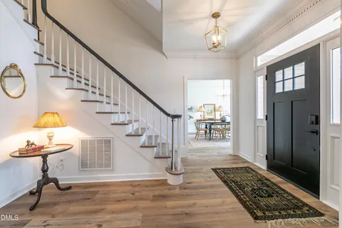a view of a dining room with furniture a chandelier and a large window