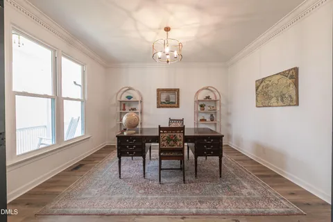 a dining room with furniture potted plants and wooden floor