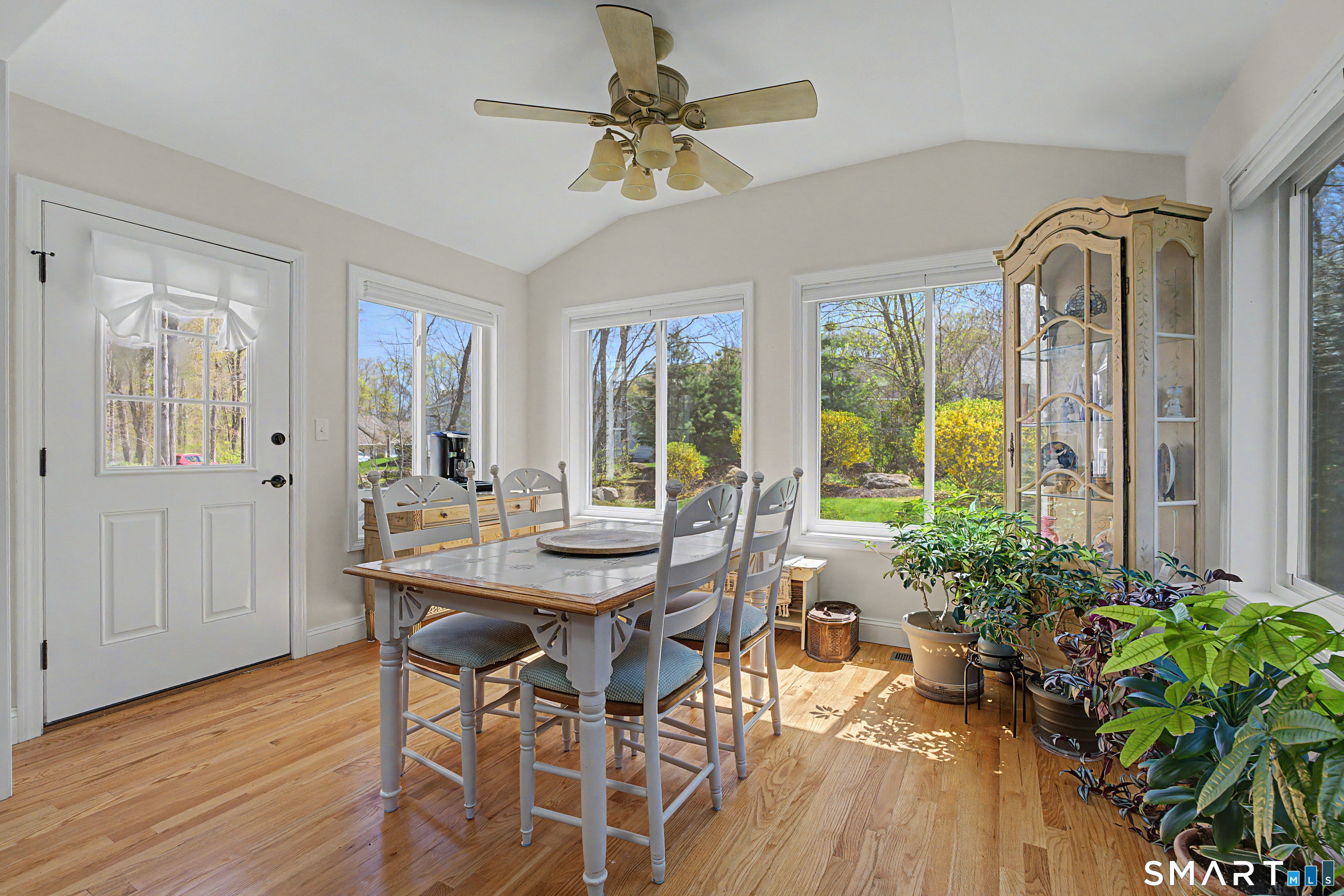 211 Meadowbrook Road, Unit 211 Oxford, CT 06478 - Photo 15 of 38 Sun-drenched dining area framed by oversized windows, offering serene views and a seamless connection to the outdoors-perfect for everyday meals or relaxed entertaining.
