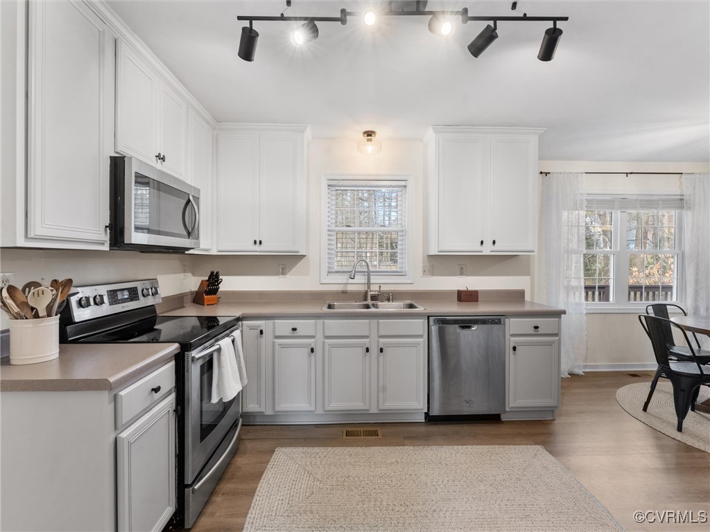 3640 Markey Road Midlothian, VA 23112 - Photo 18 of 42 a kitchen with white cabinets stainless steel appliances a sink and a window