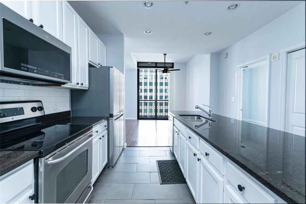 3040 Peachtree Road, Unit 1501 Atlanta, GA 30305 - Photo 1 of 1 a large kitchen with a large window and stainless steel appliances