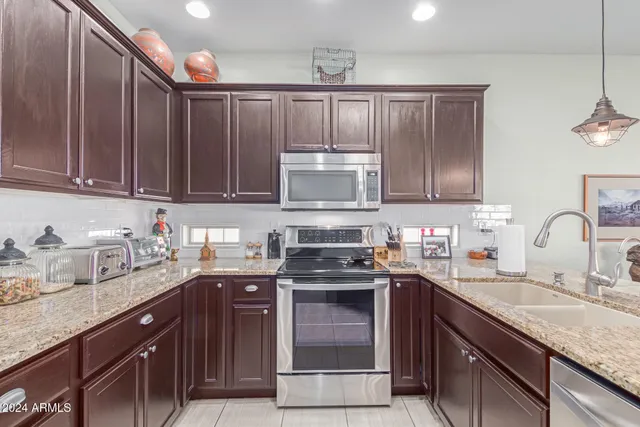 a kitchen with stainless steel appliances granite countertop a sink stove and microwave