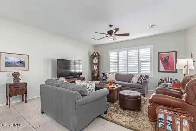 a living room with furniture ceiling fan and a window