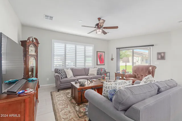 a living room with furniture a flat screen tv and a window