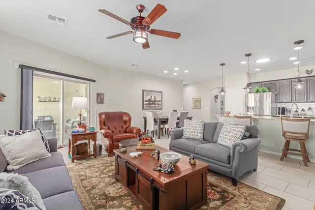 a living room with furniture kitchen view and a large window