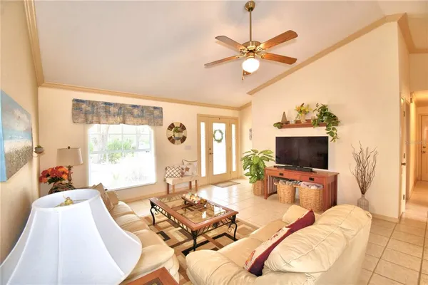 a living room with furniture a flat screen tv and a large window