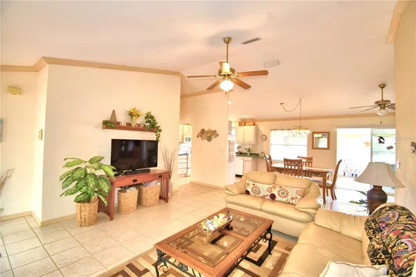 a living room with furniture a flat screen tv and a dining table