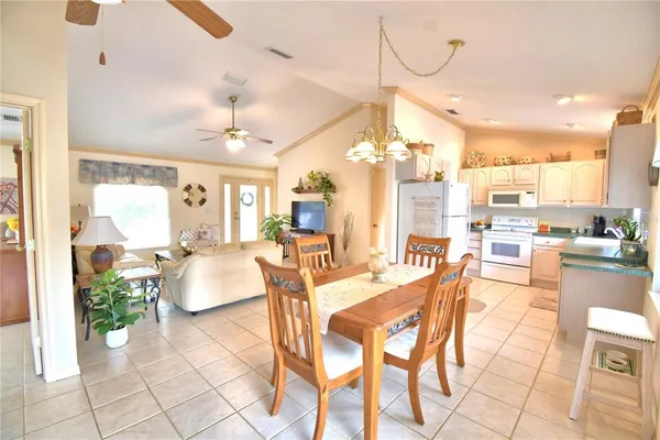 a view of a dining room and livingroom with furniture a floor to ceiling window and kitchen view