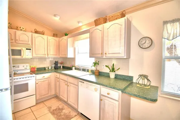 a kitchen with a sink cabinets and window