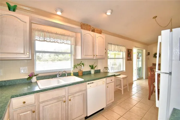 a kitchen with a sink window and cabinets