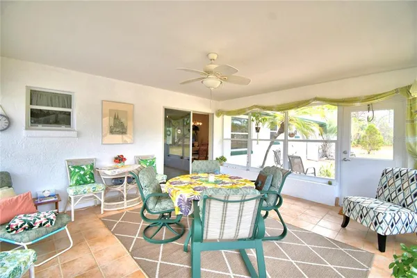 a dining room with furniture and a floor to ceiling window