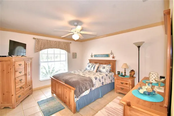 a bedroom with a bed a dresser and next to a window