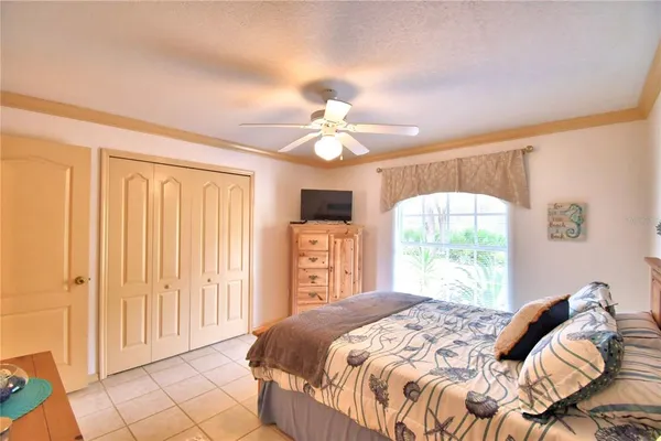 a bedroom with a bed and a large window with chandelier
