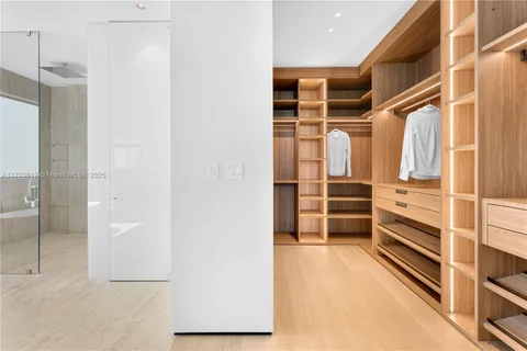 a view of walk in closet with clothes and shoes