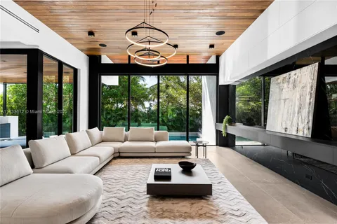 a living room with furniture a flat screen tv and a large window