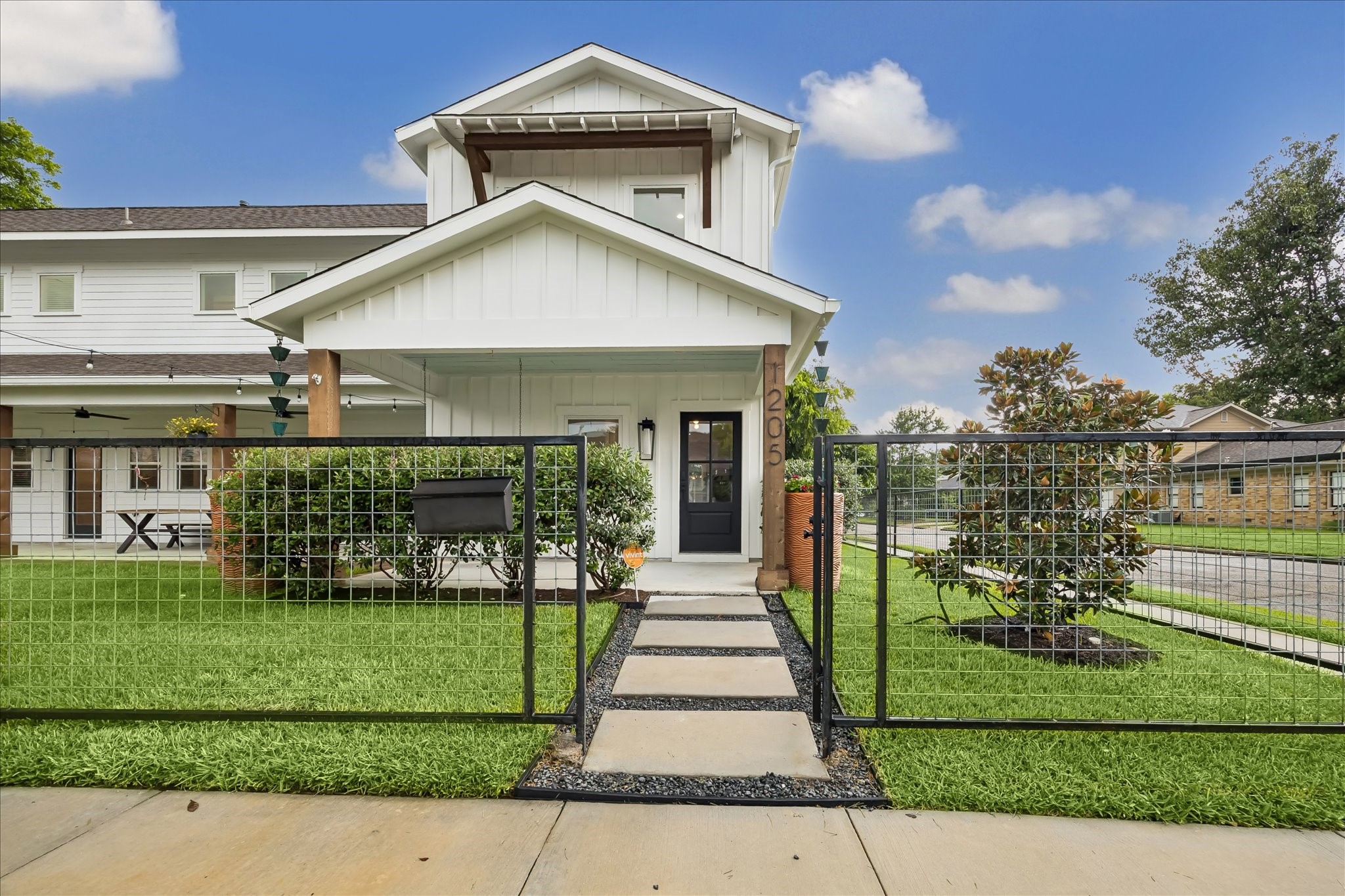 1205 Temple Street Houston, TX 77009 - Photo 2 of 33 The charming walkway and gated front yard set an inviting tone, blending timeless design with everyday functionality for both family life and entertaining.