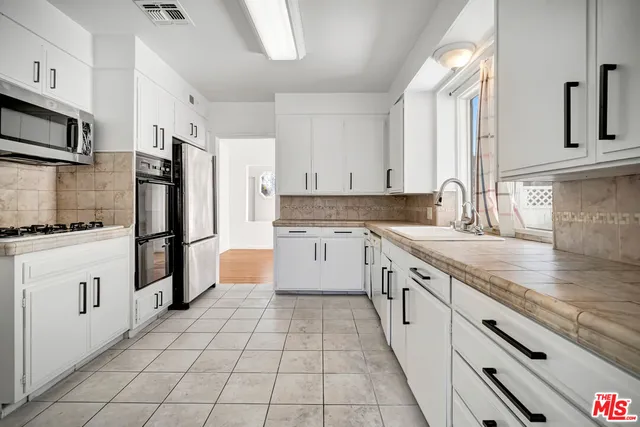 a white refrigerator freezer and a stove sitting inside of a kitchen