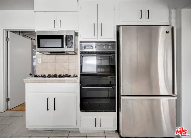 a kitchen with granite countertop cabinets stainless steel appliances and a counter space