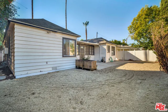 a front view of a house with a garden and trees