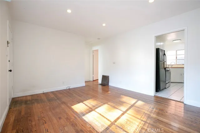 a view of empty room with wooden floor