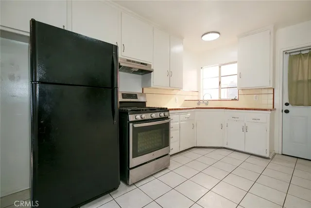 a kitchen with a refrigerator sink and cabinets