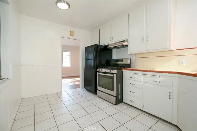 a kitchen with white cabinets appliances and sink