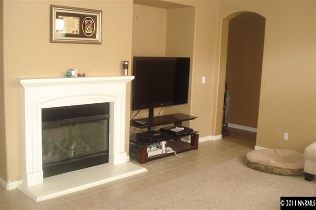 14040 Tagor Road Reno, NV 89521 - Photo 7 of 13 a living room with a fireplace and a flat screen tv
