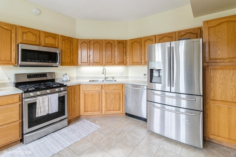 3135 Town Square Drive, Unit 106 Rolling Meadows, IL 60008 - Photo 14 of 20 a kitchen with stainless steel appliances granite countertop a refrigerator stove a sink and a microwave